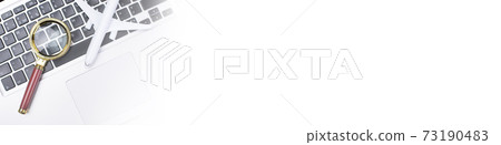 Plane and magnifying lens on laptop keyboard. Long banner Plane and magnifying lens on laptop keyboard. Long banner 73190483
