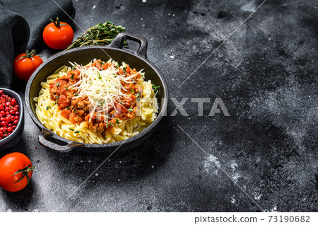 Bolognese pasta, risone with ground beef in a plate. Black background. Top view. Copy space Bolognese pasta, risone with ground beef in a plate. Black background. Top view. Copy space 73190682