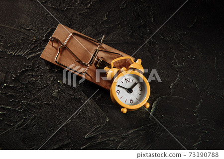 Yellow alarm clock in a mousetrap Yellow alarm clock in a mousetrap 73190788