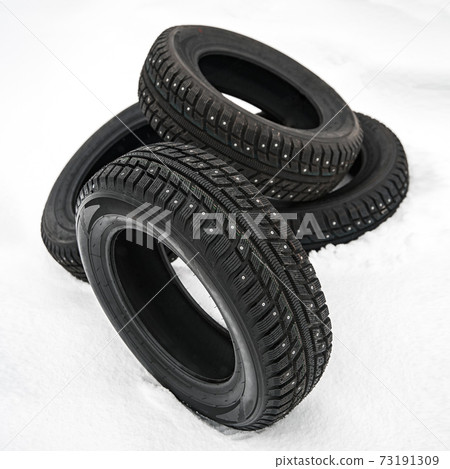 winter car tire on snow at shallow depth of field 73191309