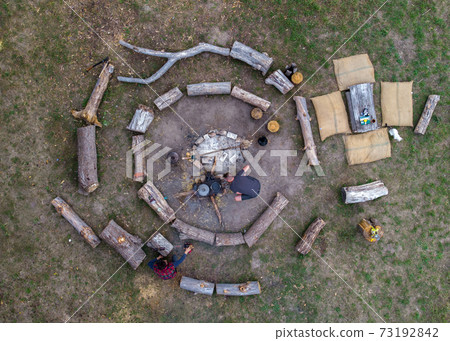 Aerial top down view of Big campfire With Circles of Logs. Bonefire for ecological Mode of life. Everyday life Cooking on the fire Aerial top down view of Big campfire With Circles of Logs. Bonefire for ecological Mode of life. Everyday life Cooking on the fire 73192842