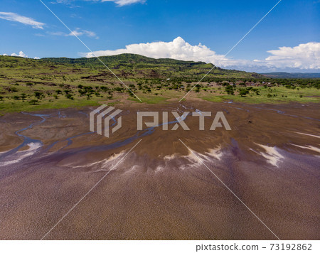 Aerial view on a Picturesque Coastline of Lake Natron in the Great Rift Valley, between Kenya and Tanzania. In the dry season the lake is 80% covered by soda and is known for its wading birds and huge 73192862