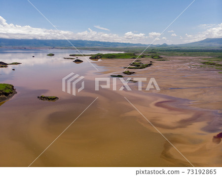 Aerial view on a Picturesque Coastline of Lake Natron in the Great Rift Valley, between Kenya and Tanzania. In the dry season the lake is 80% covered by soda and is known for its wading birds and huge Aerial view on a Picturesque Coastline of Lake Natron in the Great Rift Valley, between Kenya and Tanzania. In the dry season the lake is 80% covered by soda and is known for its wading birds and huge 73192865