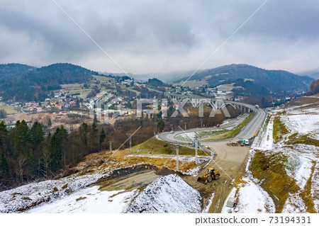 Aerial drone view on winter road construction in Polish Beskidy 73194331