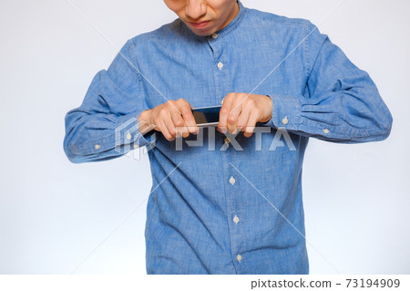 一個憤怒地打他的智能手機的人 一個憤怒地打他的智能手機的人 73194909