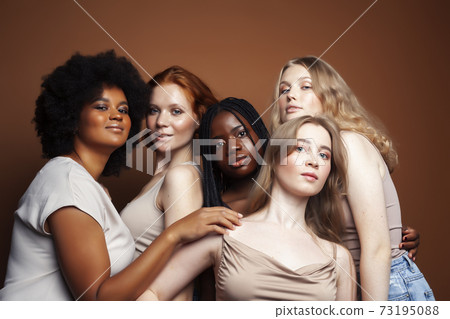 young pretty caucasian, afro, scandinavian woman posing cheerful together on brown background, lifestyle diverse nationality people concept 73195088