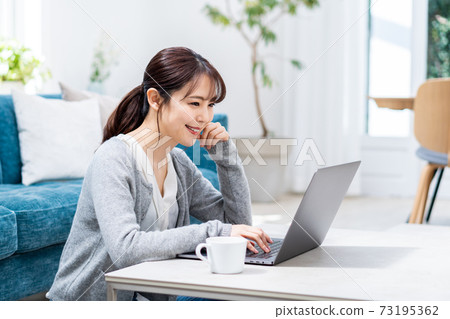年輕女子在客廳裡做遠程辦公 73195362