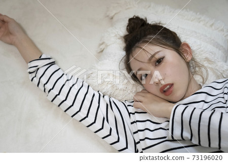 A woman relaxing in bed 73196020