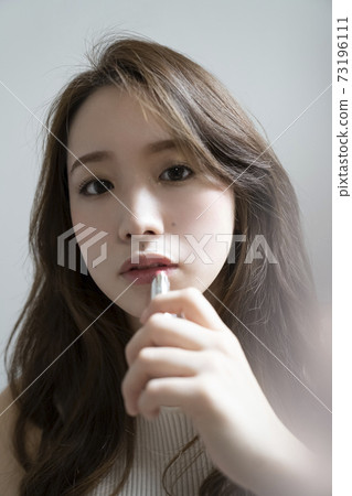 A woman applying a lip 73196111