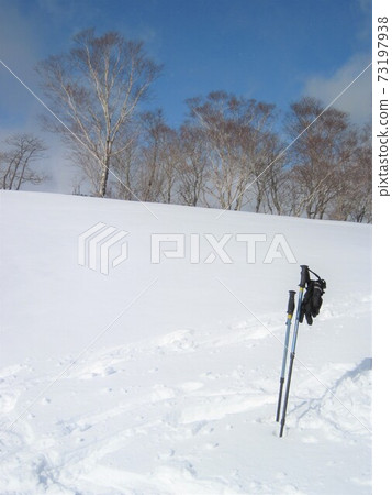 Stock set up on a snowy field during a snowshoe hike in Kamikochi 73197938