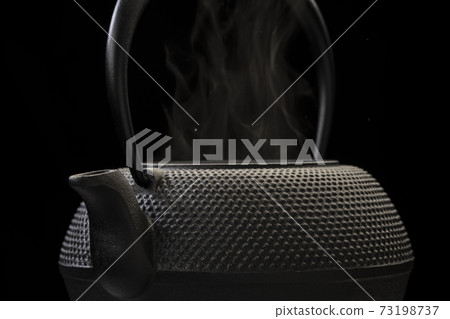 Boil water in an iron kettle 73198737