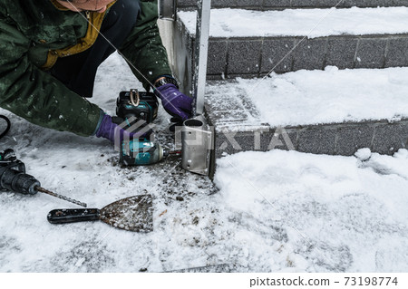 在雪中入口外的樓梯上安裝扶手 73198774