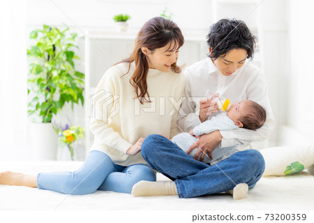 A couple giving milk to their baby A couple giving milk to their baby 73200359