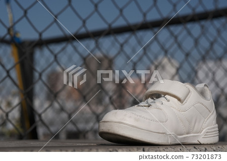 Forgotten white sneakers outside 73201873