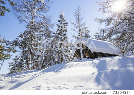 Snow-covered lodge on a sunny day Snow-covered lodge on a sunny day 73204524