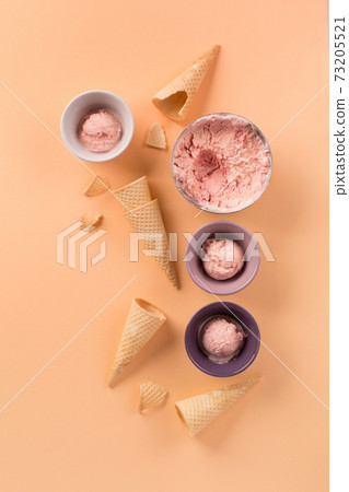 Homemade yogurt strawberry ice cream, sweet waffle cones on pastel pink background. Homemade yogurt strawberry ice cream, sweet waffle cones on pastel pink background. 73205521