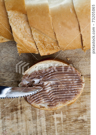 sliced white bread with sweet chocolate butter spread 73205865