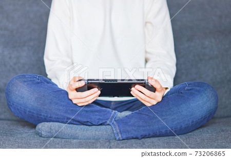 Teenager playing with a game controller [e-sports] 73206865