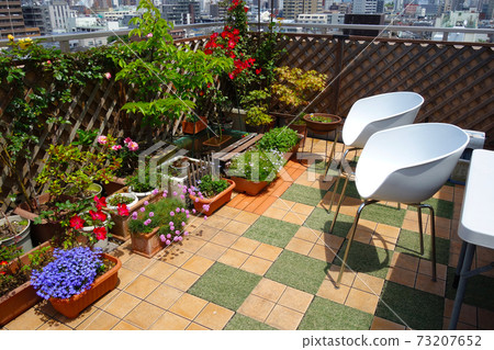在裝滿鮮花的屋頂陽台上的椅子上放鬆時間 在裝滿鮮花的屋頂陽台上的椅子上放鬆時間 73207652