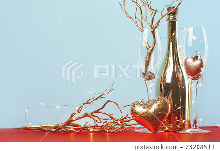 Golden heart with a bottle of champagne and two flutes. Golden heart with a bottle of champagne and two flutes. 73208511