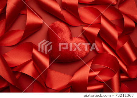 red textile heart and curled red silk ribbon red textile heart and curled red silk ribbon 73211363