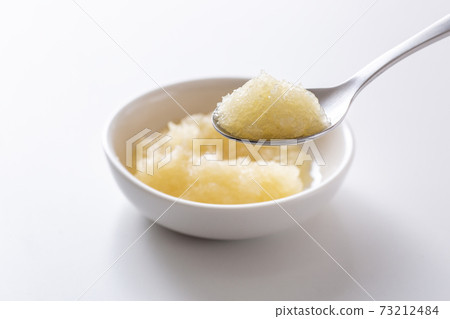 Scoop grated garlic with a spoon 73212484