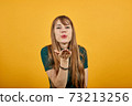 Sending sweet air kiss blowing red lips stretching hand for taking selfie 73213256