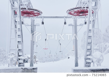 upper station of the ski lift on a snow-covered hilltop among frosty trees 73214065