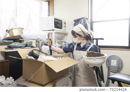 Female worker cleaning up a messy room Female worker cleaning up a messy room 73214426