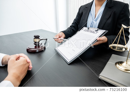 A woman lawyer or a judge counseling clients about judicial justice and prosecution with scales, judges gavel, legal documents legal services concept 73216100