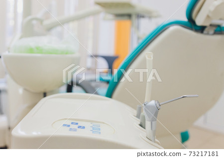 Close up of the metallic dentist tools with blue dentist chair on the background. 73217181