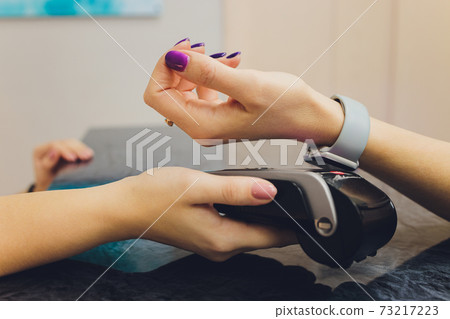 Person scanning smart watch for payment close-up. 73217223