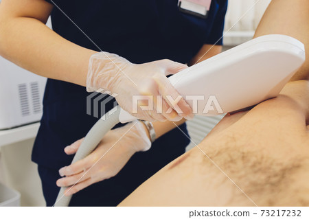 man receiving laser epilation at armpit on beauty center. man receiving laser epilation at armpit on beauty center. 73217232
