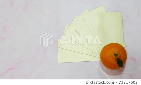 Top view of mandarin orange with a stack of golden ang pow (a monetary gift given during special occasion in Chinese culture, especially Chinese New Year). Top view of mandarin orange with a stack of golden ang pow (a monetary gift given during special occasion in Chinese culture, especially Chinese New Year). 73217602
