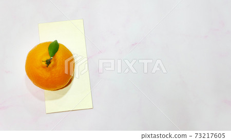 Top view of mandarin orange with a golden ang pow (a monetary gift given during special occasion in Chinese culture) underneath. Top view of mandarin orange with a golden ang pow (a monetary gift given during special occasion in Chinese culture) underneath. 73217605