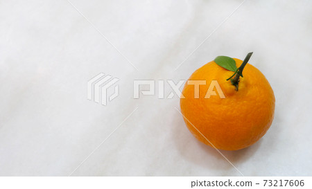 Top view of a mandarin orange on marble surface, with copy space on the left. Top view of a mandarin orange on marble surface, with copy space on the left. 73217606