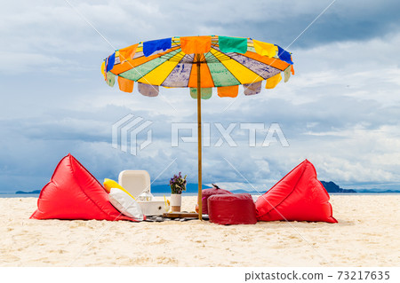 Set comfortable seats with umbrella on the beach. Set comfortable seats with umbrella on the beach. 73217635