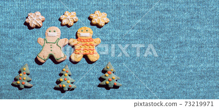 The concept of Hyper-local travel during the coronavirus pandemic. Gingerbread men surrounded by Christmas trees on a knitted background The concept of Hyper-local travel during the coronavirus pandemic. Gingerbread men surrounded by Christmas trees on a knitted background 73219971