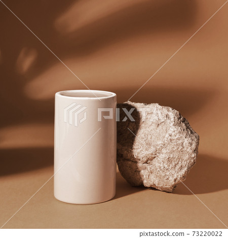 Stone and a grey glass podium on a beige background Stone and a grey glass podium on a beige background 73220022