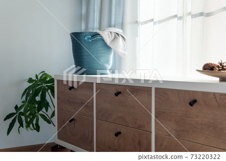 Laundry basket with gray towel. Interior of white stylish room with laundry basket Laundry basket with gray towel. Interior of white stylish room with laundry basket 73220322