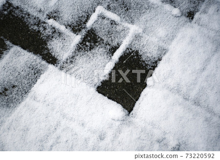 concrete paving partly covered with snow 73220592