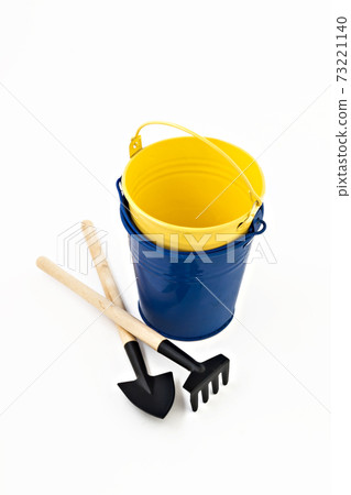 garden shovel, rake and blue metal bucket isolated 73221140