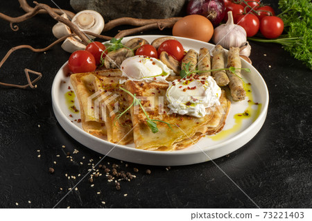 Crepe with grilled chicken sausages, mushrooms, cherry tomatoes and poached egg. A hot continental breakfast. Crepe with grilled chicken sausages, mushrooms, cherry tomatoes and poached egg. A hot continental breakfast. 73221403