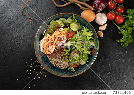 Salad with quinoa, avocado, poached egg and vegetables. Cold spicy vegetarian snack. 73221406