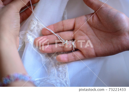 A small silver cross on a chain in a male hand. Soft focus. A small silver cross on a chain in a male hand. Soft focus. 73221433
