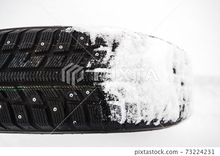 winter car tire on snow at shallow depth of field 73224231