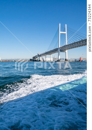 Bay Bridge in Yokohama, Japan. The scenery of the blue sky and the bridge seen from the sea. 73224344