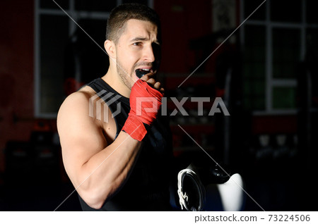 Boxing fighter putting on mouthguard. Boxing fighter putting on mouthguard. 73224506
