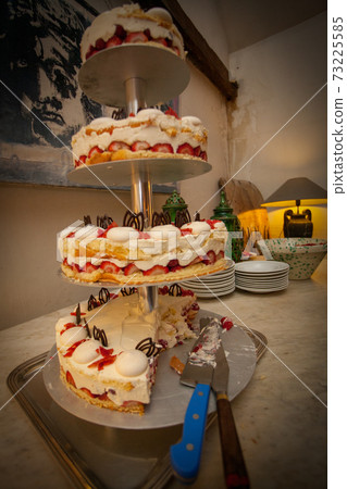 White wedding cake decorated with flowers and a stencil with the silhouette of the bride and groom 73225585