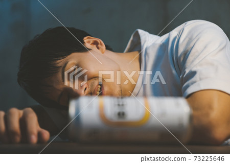 A young man who drinks canned beer and gets drunk 73225646
